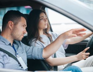 Instructor teaching student in car